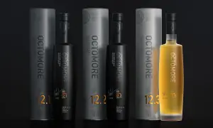 Trois bouteilles d'Octomore, whisky tourbé d'Islay, avec leurs tubes. L'une est dorée, les deux autres noires. Les étiquettes affichent des niveaux de PPM élevés, comme 130.8 PPM.