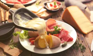Raclette, le meilleur plat français, avec pommes de terre, charcuterie et fromage fondu. Un délice réconfortant.