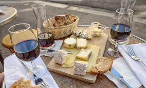 Un plateau de fromages variés, du pain et du vin rouge, une scène qui raconte une belle histoire de la cuisine française.