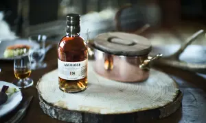 Bouteille d'Aberlour 18 ans, un whisky d'exception, posée sur une tranche de bois. Une expérience de dégustation unique, fruit d'une **création whisky** raffinée.