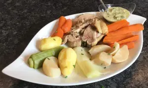 Plat de tête de veau, carottes, pommes de terre et poireaux, servi avec une sauce tartare. Une recette traditionnelle pour un repas réconfortant.