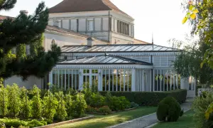 Jardin luxuriant devant une serre élégante, rappelant la beauté du caudalie vignoble.