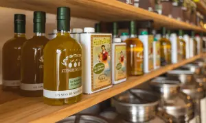 Bouteilles d'huile d'olive "Les Sens de Notre Terre", "A l'ombre de l'Oli" et "La Sélection du Luberon", évoquant les saveurs des terrasses d'Adrien.