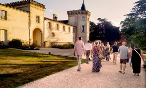 Un groupe de personnes se promène sur le chemin menant au **château Toulouse Lautrec** au coucher du soleil.