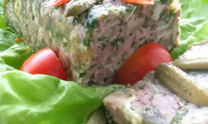 Tranche de pâté de tête maison, garnie de persil, servie sur des feuilles de laitue avec des tomates et des cornichons. Un délice pour une recette de pâté de tête.