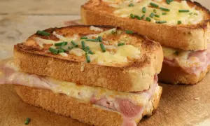 Deux croque monsieur bistrot, dorés et gratinés, garnis de jambon et fromage fondant, parsemés de ciboulette fraîche.