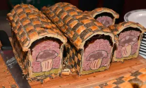 Pâté en croûte d'origine, décoré d'un champignon stylisé. Une œuvre culinaire qui raconte l'histoire de ce plat traditionnel.