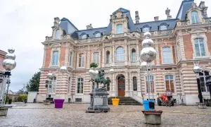 Devant un château, des sphères argentées, comme des habits de lumière, scintillent sur des structures métalliques, entourant une statue équestre.