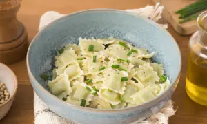 Un plat de ravioli du Dauphiné, généreusement garnis et saupoudrés de ciboulette fraîche et de poivre noir.