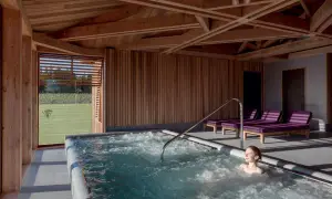 Détente dans un chateau spa à Bordeaux. Une femme profite d'un jacuzzi avec vue sur les vignes.