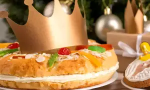 Un gâteau pour accompagner le champagne, décoré de fruits confits et d'une couronne dorée, prêt pour une fête royale.
