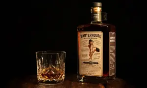 Verre de bourbon ambré et bouteille Orphan Barrel Barterhouse 20 ans. Une dégustation pour apprécier la différence whiskey bourbon.
