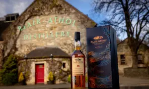 Bouteille de whisky Blair Athol 20 ans et sa boîte devant la distillerie.