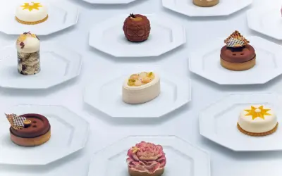 Collection de petits gâteaux raffinés, un véritable produit de luxe alimentaire, présentés sur des assiettes blanches.