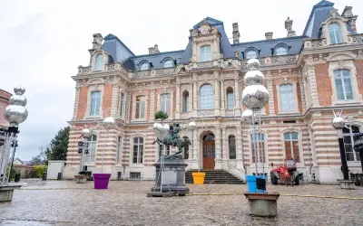 Devant un château, des sphères argentées, comme des habits de lumière, scintillent sur des structures métalliques, entourant une statue équestre.
