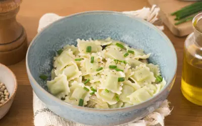 Un plat de ravioli du Dauphiné, généreusement garnis et saupoudrés de ciboulette fraîche et de poivre noir.