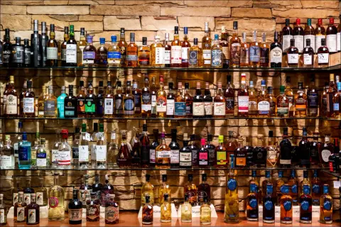 Étagères remplies de bouteilles de whisky et de champagne, un festin pour les amateurs de spiritueux.