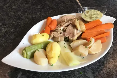 Plat de tête de veau, carottes, pommes de terre et poireaux, servi avec une sauce tartare. Une recette traditionnelle pour un repas réconfortant.