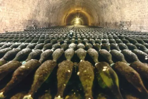 Des milliers de bouteilles de champagne vieillissent dans les caves voûtées de la visite cave Deutz.