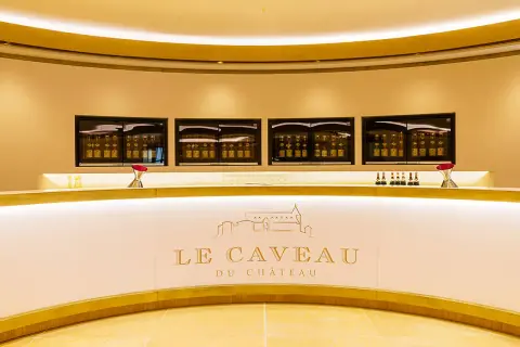 Le caveau Guigal, un comptoir moderne avec des bouteilles de vin exposées dans des vitrines lumineuses.