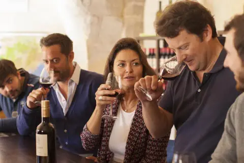 Des personnes participent à une dégustation de vin à Montpellier, savourant un verre de rouge.