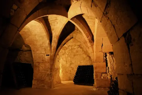 Cave voûtée de la maison Taittinger à Reims, où des milliers de bouteilles de champagne vieillissent patiemment.