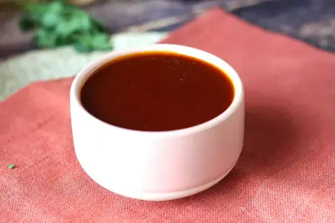 Un bol de sauce barbecue maison, parfaite pour accompagner vos grillades. Une recette simple pour un goût authentique.