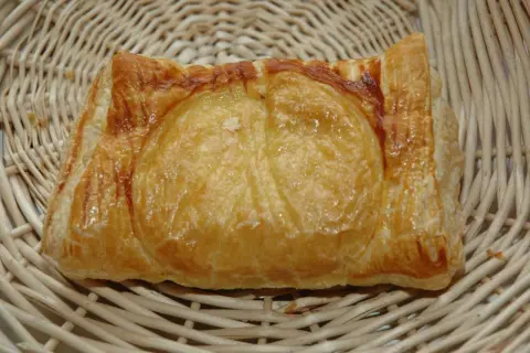 Un feuilleté de ris de veau doré et croustillant, présenté dans un panier en osier. Un délice à savourer.