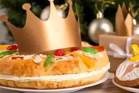 Un gâteau pour accompagner le champagne, décoré de fruits confits et d'une couronne dorée, prêt pour une fête royale.