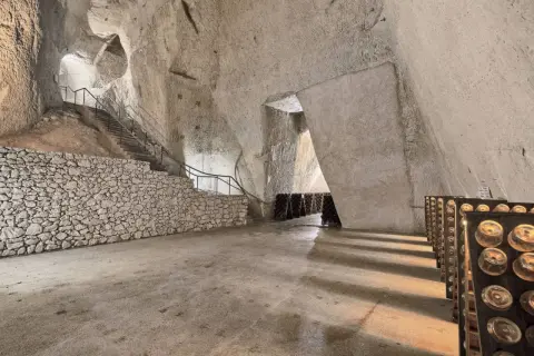 Visite cave Ruinart : avis sur ces crayères historiques où le champagne vieillit. Bouteilles en pupitres, escaliers de pierre.