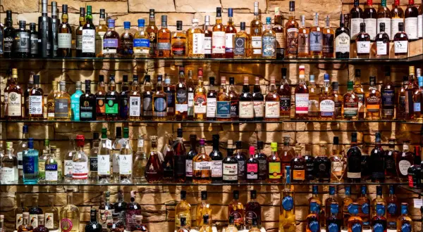 Étagères remplies de bouteilles de whisky et de champagne, un festin pour les amateurs de spiritueux.