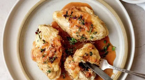 Trois morceaux de poulet généreusement nappés d'une sauce onctueuse, garnie de thym frais. Un plat qui évoque la richesse de la gastronomie lyonnaise.