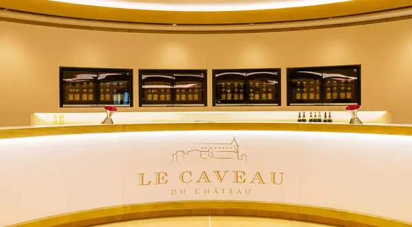 Le caveau Guigal, un comptoir moderne avec des bouteilles de vin exposées dans des vitrines lumineuses.
