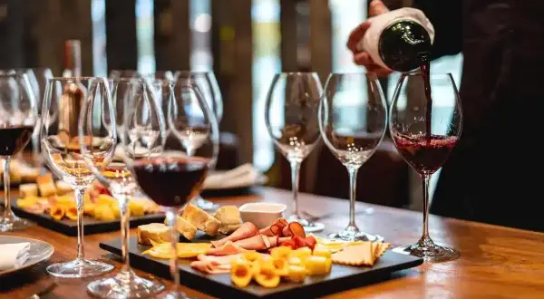 Une dégustation de vin à Paris, avec des verres remplis de vin rouge et des plateaux de fromages et charcuteries.