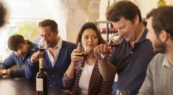 Des personnes participent à une dégustation de vin à Montpellier, savourant un verre de rouge.