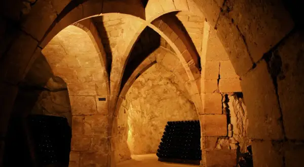 Cave voûtée de la maison Taittinger à Reims, où des milliers de bouteilles de champagne vieillissent patiemment.