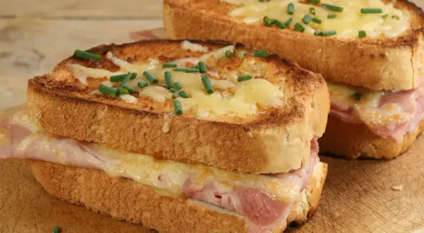 Deux croque monsieur bistrot, dorés et gratinés, garnis de jambon et fromage fondant, parsemés de ciboulette fraîche.