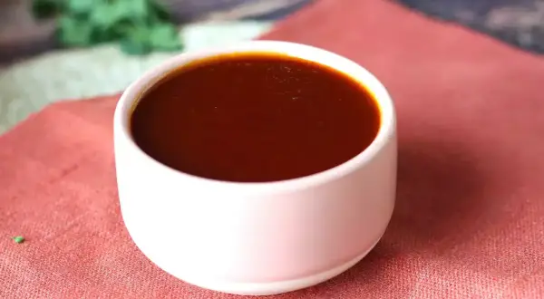Un bol de sauce barbecue maison, parfaite pour accompagner vos grillades. Une recette simple pour un goût authentique.