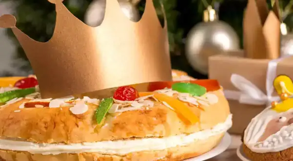 Un gâteau pour accompagner le champagne, décoré de fruits confits et d'une couronne dorée, prêt pour une fête royale.