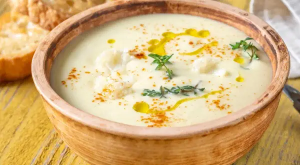 Un onctueux potage Dubarry, garni de chou-fleur, d'huile d'olive et de thym, servi avec des toasts grillés.
