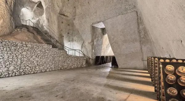 Visite cave Ruinart : avis sur ces crayères historiques où le champagne vieillit. Bouteilles en pupitres, escaliers de pierre.