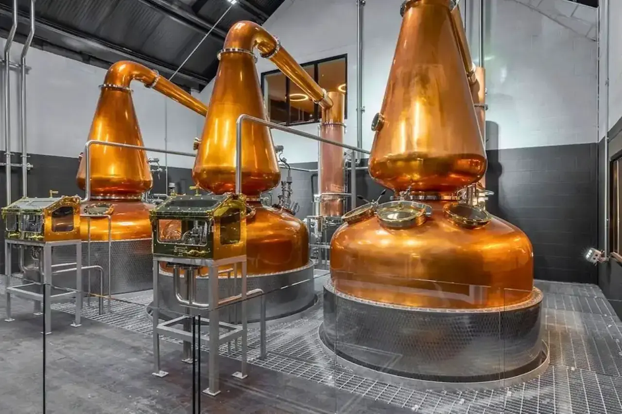 Alambics en cuivre brillants dans une distillerie, prêts à produire le meilleur whisky de Dublin.