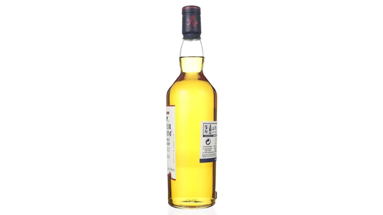 Bouteille de whisky Talisker Dark Storm, ambré, avec étiquette blanche et rouge. Le bouchon est bleu marine avec un lion rouge.
