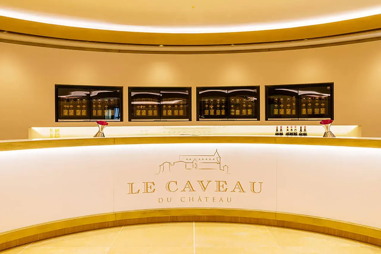 Le caveau Guigal, un comptoir moderne avec des bouteilles de vin exposées dans des vitrines lumineuses.