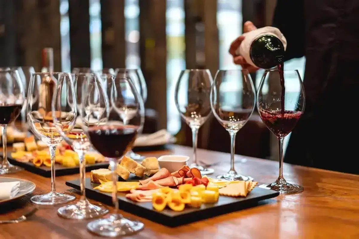 Une dégustation de vin à Paris, avec des verres remplis de vin rouge et des plateaux de fromages et charcuteries.