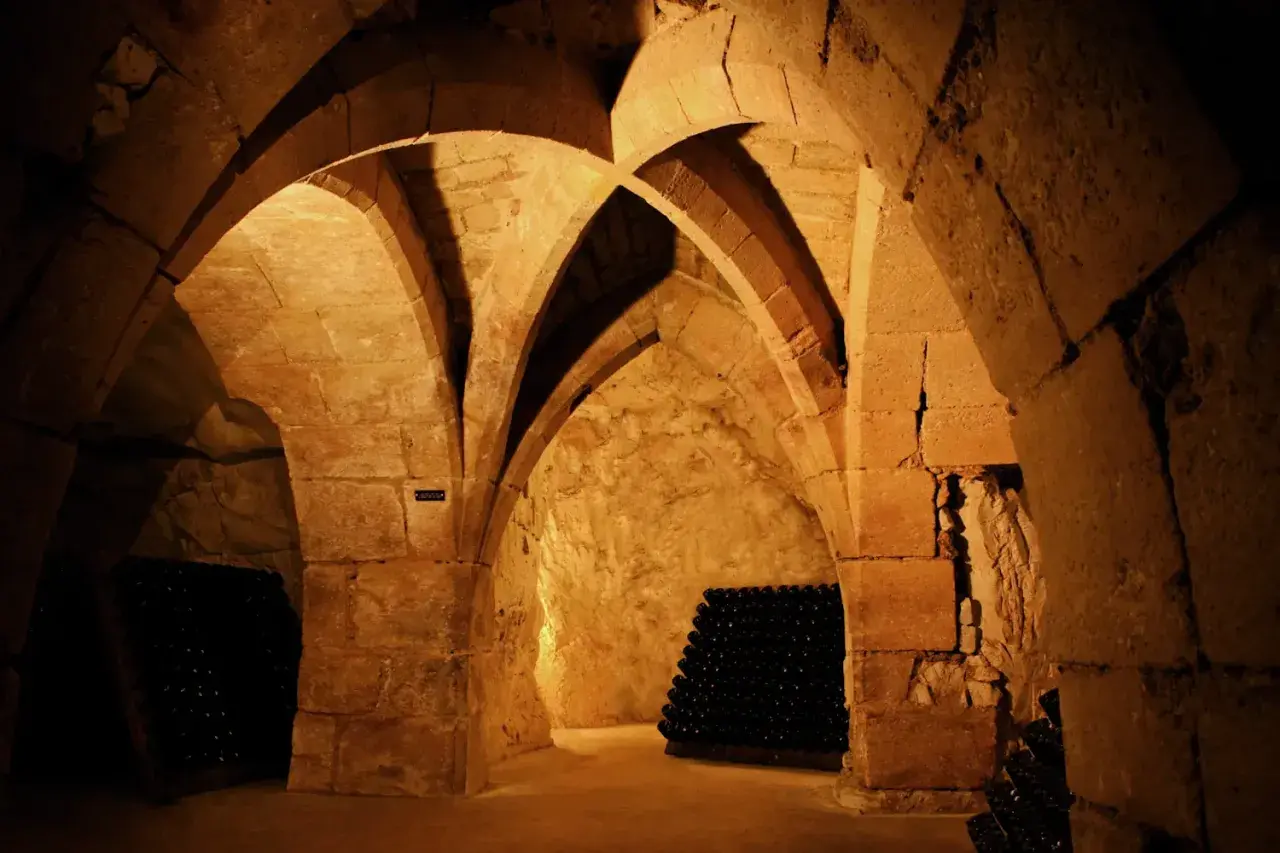 Cave voûtée de la maison Taittinger à Reims, où des milliers de bouteilles de champagne vieillissent patiemment.