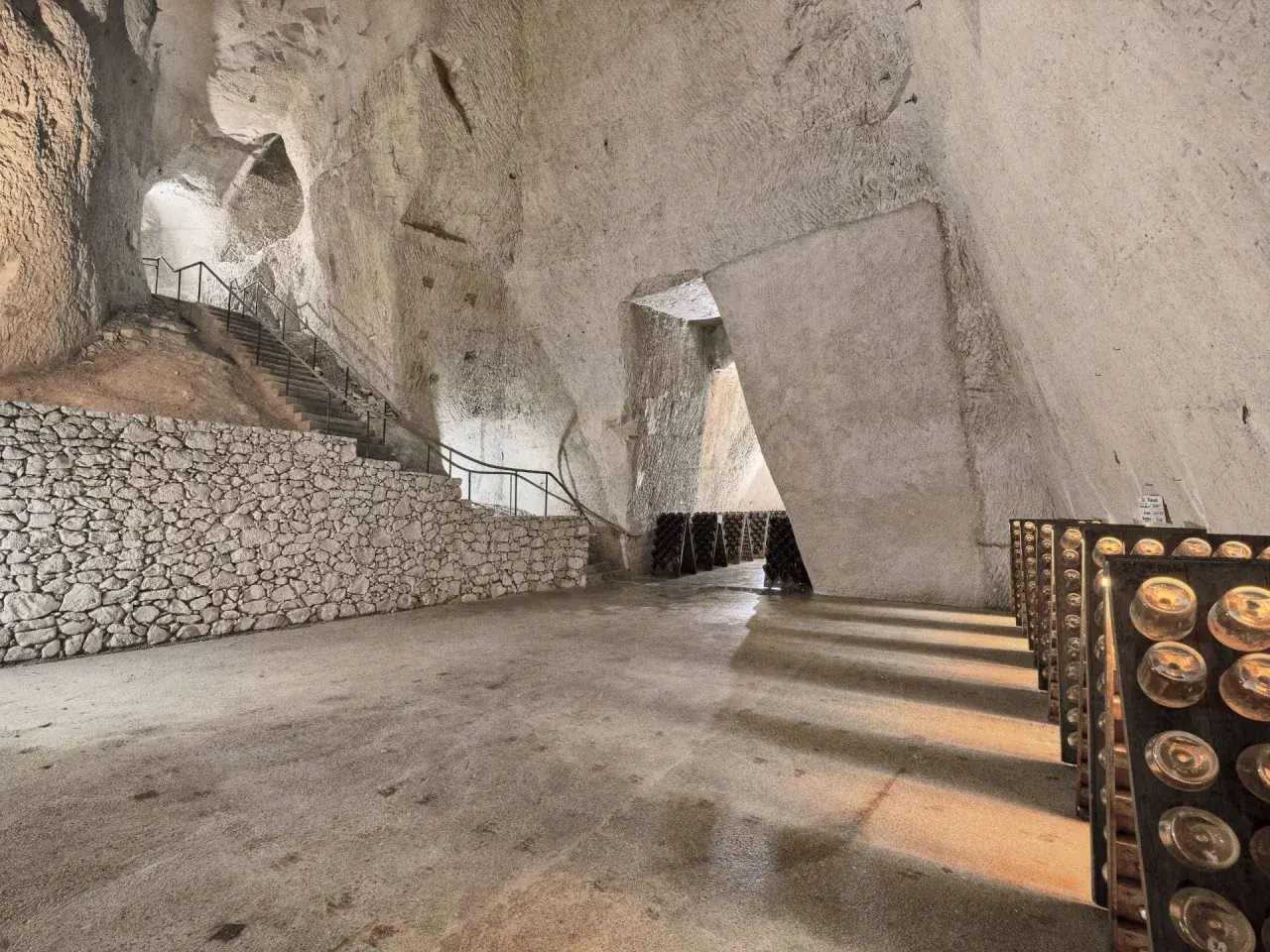 Visite cave Ruinart : avis sur ces crayères historiques où le champagne vieillit. Bouteilles en pupitres, escaliers de pierre.