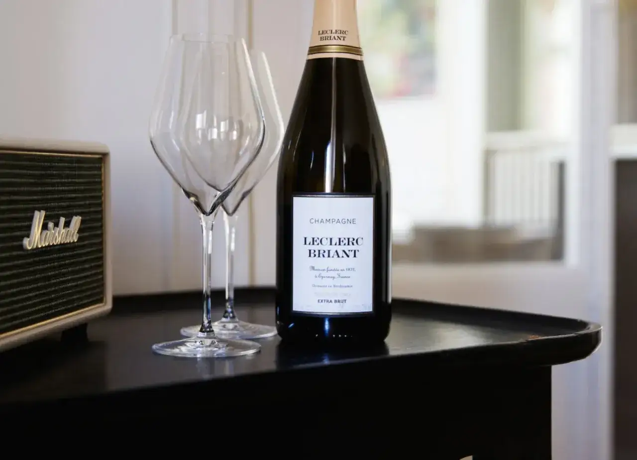 Une bouteille de champagne Leclerc Briant, le 25bis, est prête à être dégustée avec deux verres.