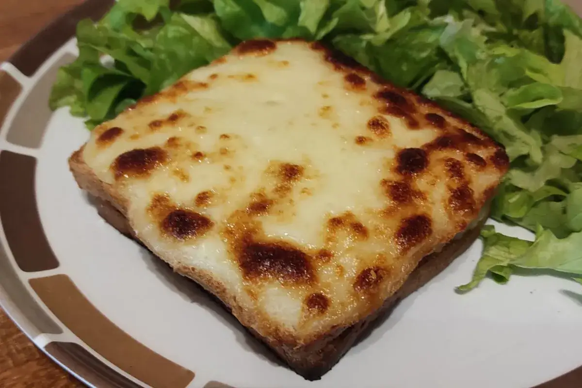 Un d&eacute;licieux croque monsieur bistrot, gratin&eacute; &agrave; la perfection, servi avec une salade verte croquante.
