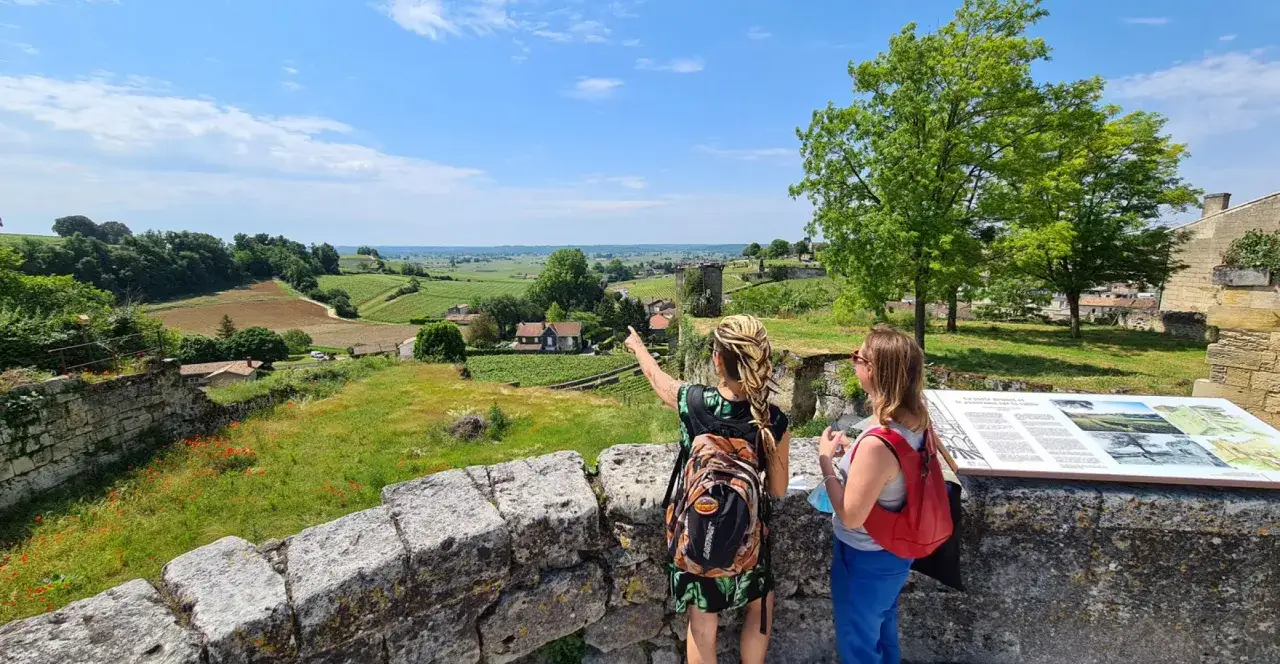 Deux femmes admirent le paysage viticole de la route des vins de Saint-&Eacute;milion.